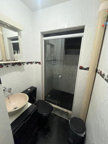 a bathroom with a shower and a toilet and a sink at Quarto Hostel Curitiba in Curitiba