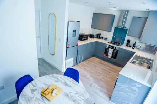 a kitchen with a table and blue cabinets at Caasi Homes in Leigh