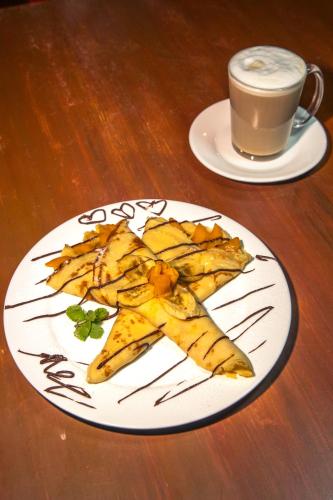 a plate of food on a table with a cup of coffee at Chill Out Hostel in Boracay
