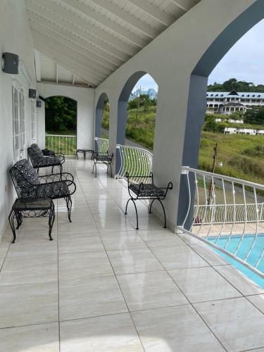 a porch with chairs and a swimming pool at Sugarbird Villa in Black Rock