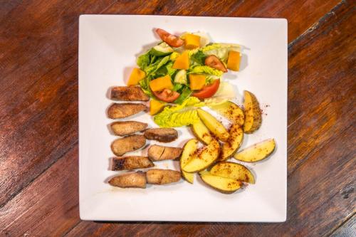 a plate of food with potatoes and vegetables on a table at Chill Out Hostel in Boracay