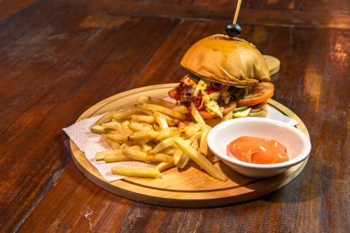 a sandwich and fries on a plate with a bowl of ketchup at Chill Out Hostel in Boracay