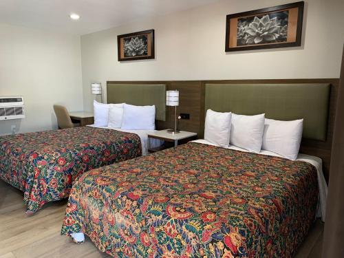 a hotel room with two beds and a table at Big 7 Motel in Chula Vista