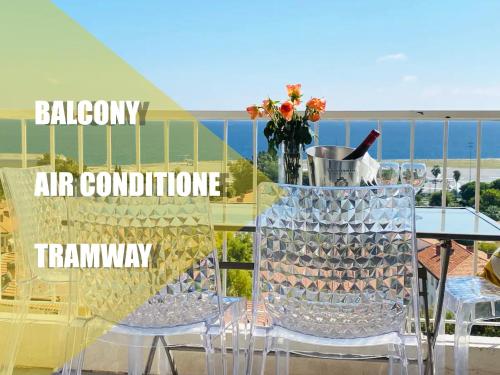 uma garrafa de vinho sentada numa mesa na varanda em Panoramic Sea view - Balcony - Tramway - 2 Bedrooms - Wifi - Fully equipped kitchen em Nice