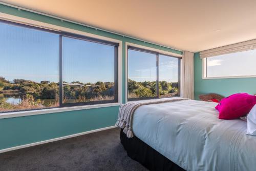 Ono في Te Horo: غرفة نوم بسرير ونوافذ كبيرة