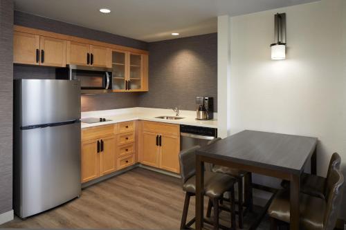 a kitchen with a refrigerator and a table with chairs at Residence Inn by Marriott Montreal Airport in Dorval