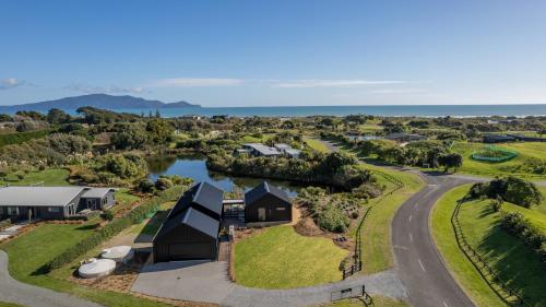 an aerial view of a house with a road and a lake at Ono in Te Horo