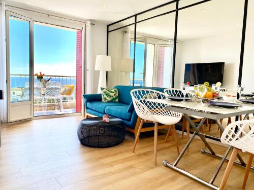 een woonkamer met een blauwe bank en een tafel bij Panoramic Sea view - Balcony - Tramway - 2 Bedrooms - Wifi - Fully equipped kitchen in Nice