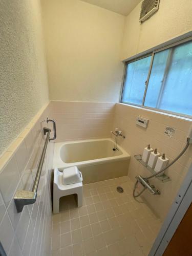 a bathroom with a bath tub and a toilet at 島の宿 近 別邸〜縁〜 in Oshima