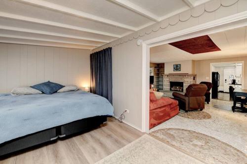 een slaapkamer met een bed en een woonkamer bij Clintonville Bungalow Under The Pines in Columbus