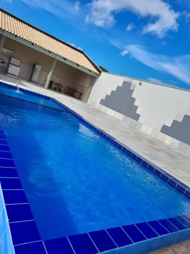 una piscina con acqua blu di fronte a una casa di A B EVENTOS a Juazeiro do Norte