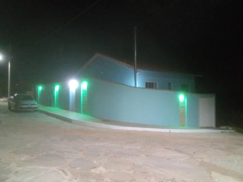 une voiture garée devant un bâtiment la nuit dans l'établissement Casa Beija Flor, à São Thomé das Letras