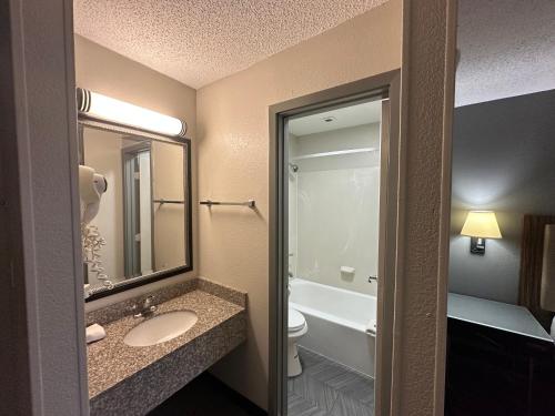 BlissPoint Inn Northwest Indianapolis في انديانابوليس: حمام مع حوض ومرحاض ومرآة