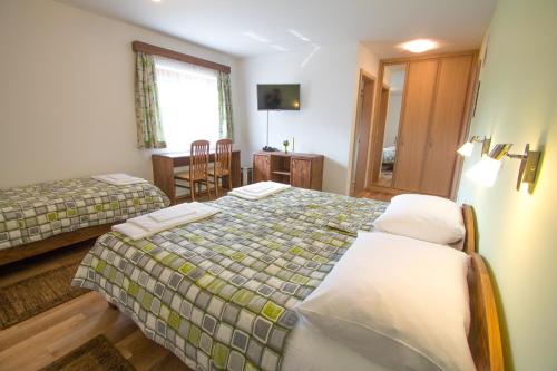 a bedroom with two beds and a table and a window at Tourist farm Megušar in Škofja Loka