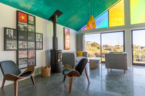 a living room with chairs and a fireplace at Ono in Te Horo