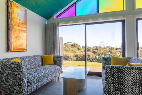 a living room with two chairs and a glass table at Ono in Te Horo