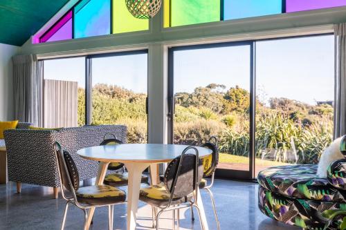 a room with a table and chairs and a window at Ono in Te Horo