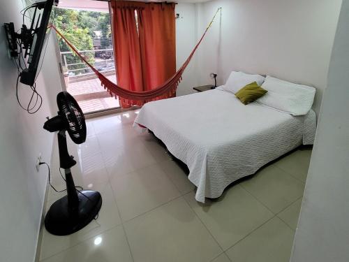 a bedroom with a bed and a window with a hammock at Espectacular y amplio apartamento amoblado in Barranquilla