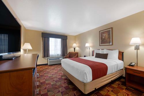 a hotel room with a large bed and a desk at Best Western Laramie Inn & Suites in Laramie