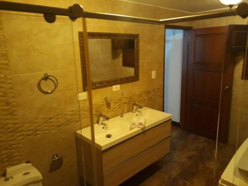 ein Bad mit einem Waschbecken und einem Spiegel in der Unterkunft Casa Carambolo in Cali