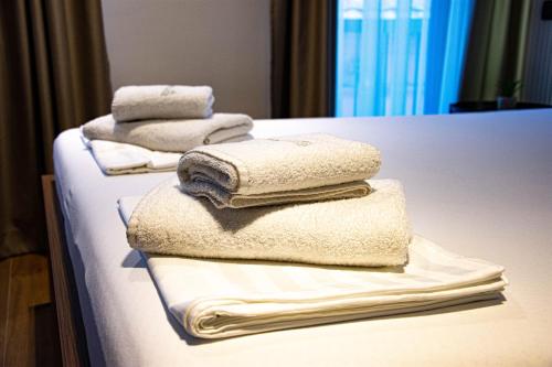 シャバツにあるKristall Apartments Premiumのベッドにタオルを積み重ねています。