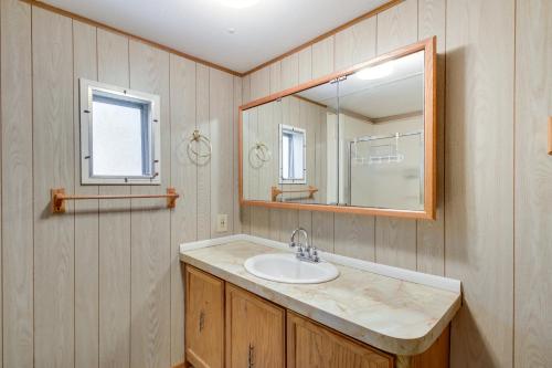 a bathroom with a sink and a mirror at Waterfront Wahkon Home with Wraparound Deck and Docks in Isle