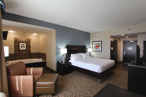a large hotel room with a bed and a couch at Hilton Garden Inn Findlay in Findlay