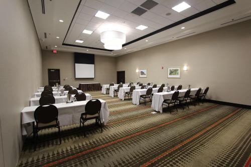 a conference room with tables and chairs and a screen at Hilton Garden Inn Findlay in Findlay
