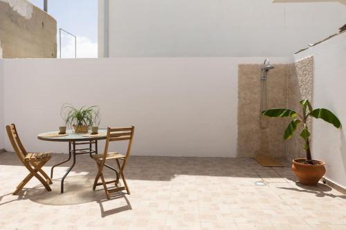 La Casita del Sol في Soo: طاولة وكراسي في غرفة مع نبات الفخار