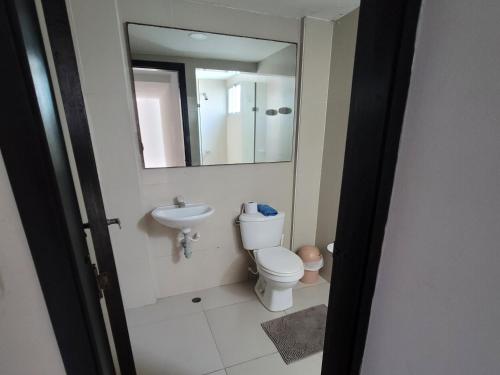 a bathroom with a toilet and a sink and a mirror at Espectacular y amplio apartamento amoblado in Barranquilla