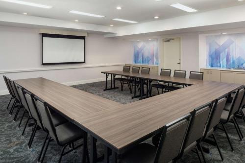 a conference room with tables and chairs and a screen at Hilton Garden Inn Arcadia/Pasadena Area in Arcadia