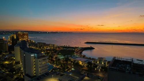 a view of a city with the ocean at sunset at Hilton Okinawa Chatan Resort in Chatan