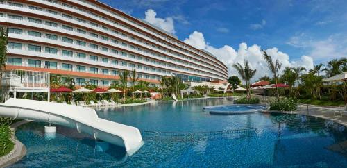 a large hotel with a slide in a swimming pool at Hilton Okinawa Chatan Resort in Chatan