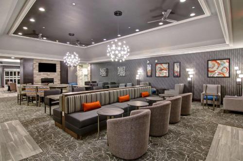a lobby with a waiting room with couches and tables at Homewood Suites by Hilton Burlington in Burlington