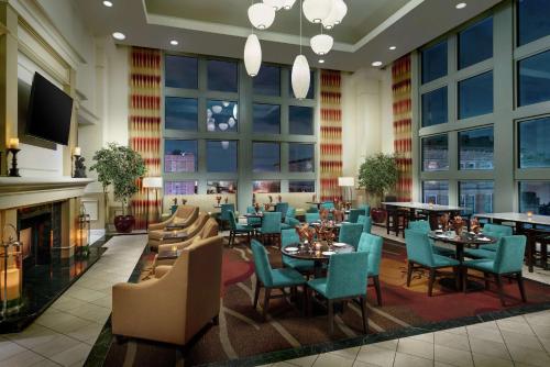 a restaurant with tables and chairs and a fireplace at Hilton Garden Inn Philadelphia Center City in Philadelphia