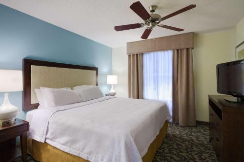 a bedroom with a bed with a ceiling fan and a television at Homewood Suites by Hilton Raleigh-Durham Airport at RTP in Durham
