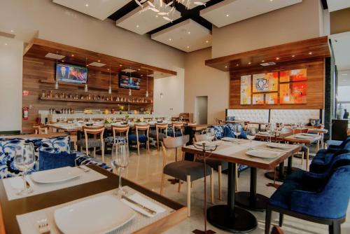 a restaurant with tables and chairs and a bar at Hilton Garden Inn Puebla Angelopolis in Puebla