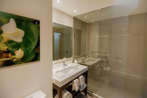 a bathroom with two sinks and a mirror at Hilton Garden Inn Puebla Angelopolis in Puebla