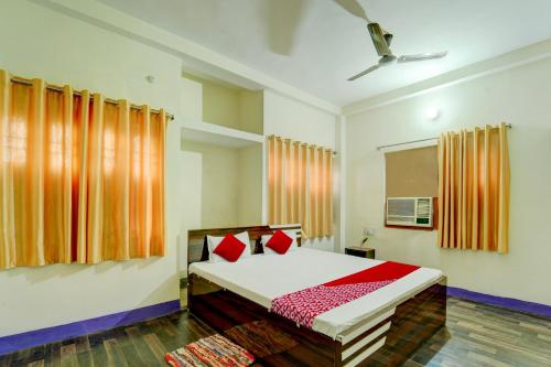 a bedroom with a bed with red pillows at OYO Flagship Hotel Shubhmangalam in Patna
