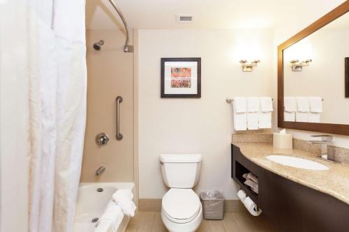 a bathroom with a toilet and a sink and a tub at Hilton Garden Inn Palm Springs/Rancho Mirage in Rancho Mirage