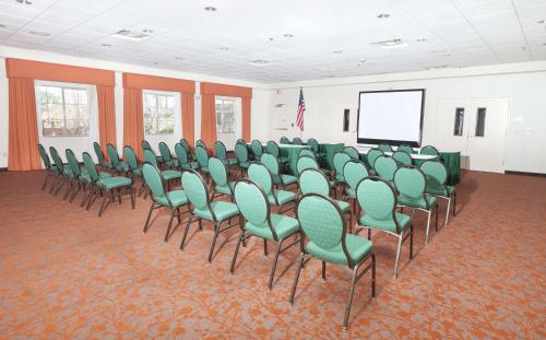 a conference room with green chairs and a screen at Hilton Garden Inn Palm Springs/Rancho Mirage in Rancho Mirage