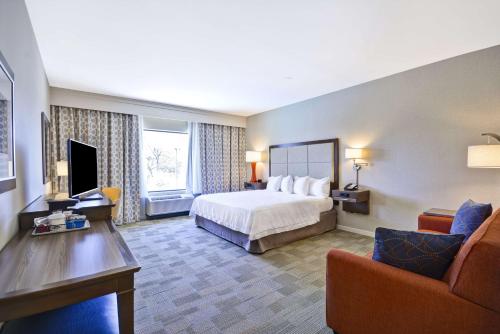 a large hotel room with a bed and a couch at Hampton Inn & Suites Dallas/Plano-East in Plano