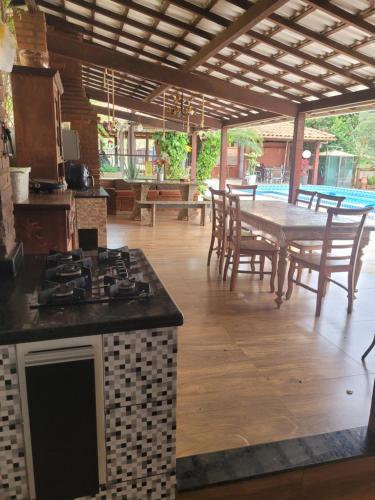 a kitchen with a stove and a table with chairs at Refúgio Bonanza in Teixeiras