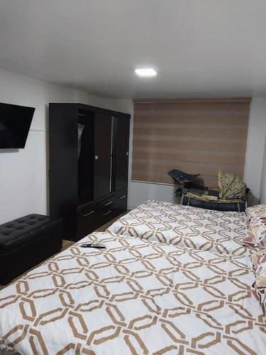 1 dormitorio con 1 cama grande y 1 silla en Departamento moderno y amoblado, en Quito