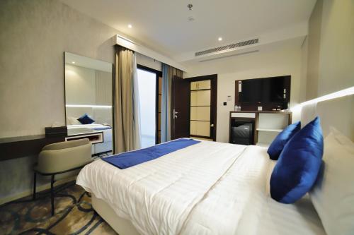a bedroom with a large bed with blue pillows at شقق زوايا الماسية العوالي in Al Madinah