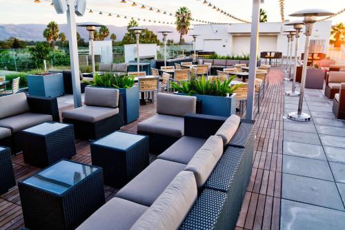 a patio with couches and tables and chairs at Hilton Garden Inn Santa Barbara/Goleta in Santa Barbara