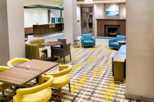 a lobby with tables and chairs and a fireplace at Hilton Garden Inn Santa Barbara/Goleta in Santa Barbara