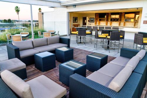 a patio with couches and tables and a bar at Hilton Garden Inn Santa Barbara/Goleta in Santa Barbara