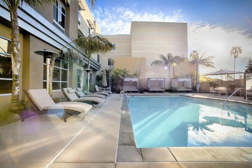 a swimming pool with lounge chairs and a building at Hilton Garden Inn Santa Barbara/Goleta in Santa Barbara
