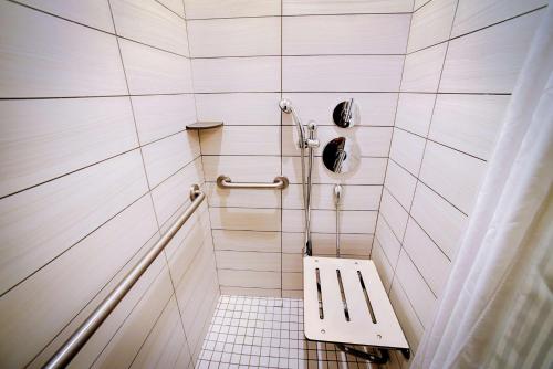 a white tiled shower with a bench in a bathroom at Hilton Garden Inn Santa Barbara/Goleta in Santa Barbara